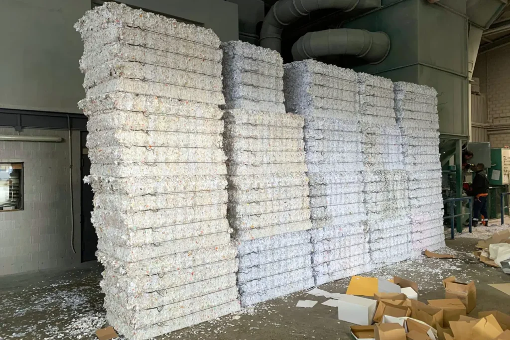 White paper bales stored inside a recycling facility after compaction and tying